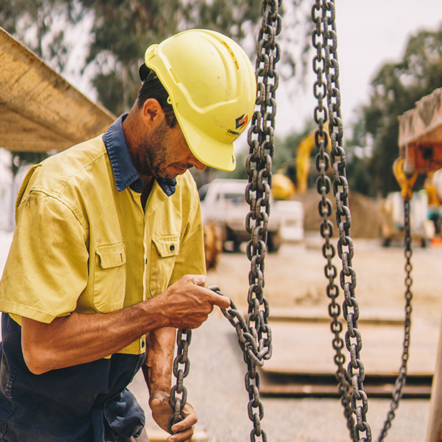 Construction worker lifting chains