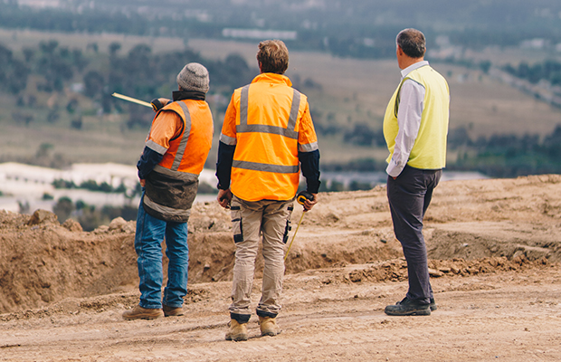 Team of workers dressed in high vis looking out over valley