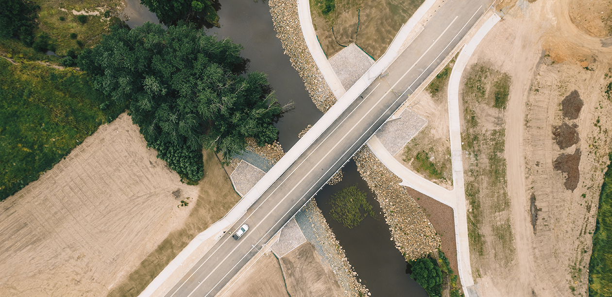 Drone bird's eye view of a car crossing a bridge over water.bridge